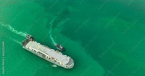 Roll-on Roll-of ship and tugboat sailing in sea, business services import export new car line up and goods international by Roll-on Roll-of ship large in the Ocean freight, 4k video aerial view,