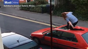 Woman launches furious attack on car as it drives away