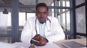 Black male doctor talking to web cam consulting patient via virtual telemedicine advice. African physician making online telehealth video call for remote appointment tele health care chat. Webcam view