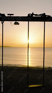 Beach swing with ocean waves and sunset background. Santa Fe, Tablas, Romblon. Philippines. Vertical view.