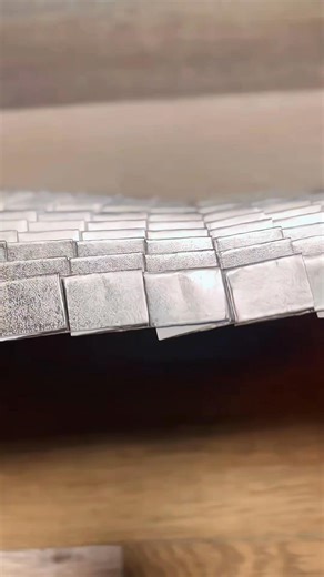 Origami artwork titled "Infinity" by artist D.Hinklay. It is made entirely from a single piece of paper without any cuts. The complex, geometric, and textured design is achieved through intricate folding techniques | GIGadgets