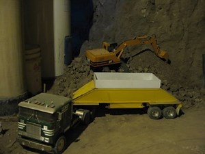 Man digs out basement with R/C construction equipment models