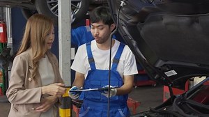clip-1095151093-mechanic-giving-contract-document-customer-asian-woman