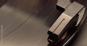 slider move on a retro record players needle dropping on to a vintage vinyl music album, right to left