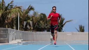 Sprinter man running sprint training on athletics track and field stadium fast at high speed. Male athlete runner in intense sprint exercise. Run sport concept. SLOW MOTION 59.94 FPS.