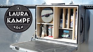 Woman builds cool camping kitchen in a suitcase.