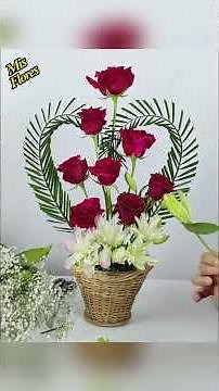 Heart-shaped arrangement with roses and palm leaves