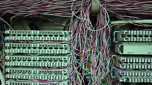 Inside a PABX telephone booth that has a number of connecting cables in many colors in the analog system. communication technology