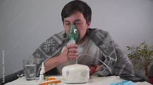Man does inhalation at home during an illness pneumonia, infection with coronavirus covid 19. Medical inhaler, nebulizer, nebular. Asthma breathing treatment. Bronchitis, asthmatic health equipment.