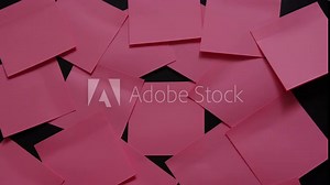 Pink sticky notes attached to a black board. Concept of a hard day at the office with notes or a list of tasks to be completed. stop motion