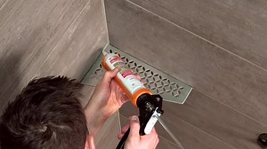 The SHELF-E can be installed in tandem with the tile, or as a retrofit application. Here we show how to install this corner shelf in conjunction with the tile: | Schluter-Systems North America