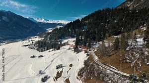 Aerial view of Landwasser Viaduct and Bernina express in Swiss Alps snow winter scenery. Drone shot red train passing through mountain in Filisur, Switzerland. Stock Video