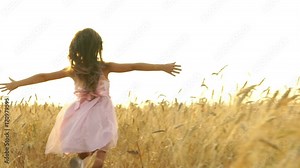 pretty girl in the dress is running across the field.