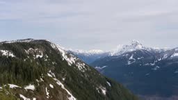 Time Lapse of the clouds passing by in the sky with mountains in the...