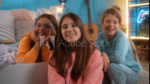 Portrait of three cheerful teenage girls smiling looking at the camera while in a room with neon lights