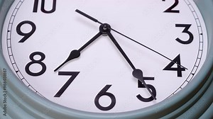Time lapse Close-up white wall clock with black numbers tells the time 7:12 a.m.
