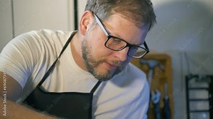 A man repairman makes repairs and repairs electronics in a home appliance repair shop