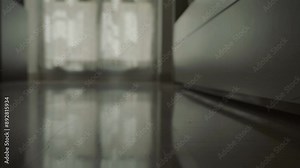 A close-up of a woman's feet stepping into slippers as she leaves the bed in a darkened room, early morning. The scene depicts the start of her day in a peaceful home environment.