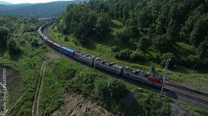 Baikal, Russia - 2021: A passenger train rides along the mountains on a sunny day. Russian Railways. Electric train. Trip. Journey. Transport.