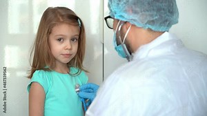Back view male doctor pediatrician uses stethoscope listen heart of child girl patient. Lung breathing check. Medicine and healthcare concept.