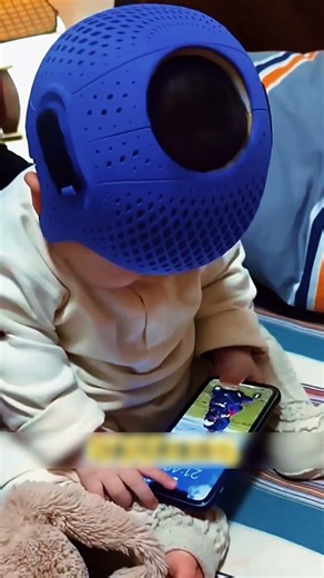 Grandma puts a hat on the baby to correct his head shape.
