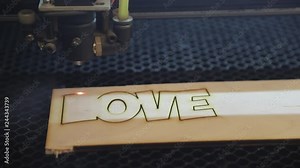 the process of the operator on the laser equipment, working with a laser machine, cutting parts from plywood on the machine
