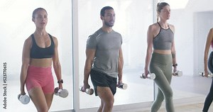 Group of fit, active and athletic diverse people exercising together in a health club or class in a gym. Team of athletes doing the leg lunges exercise or workout for fitness and cardio training