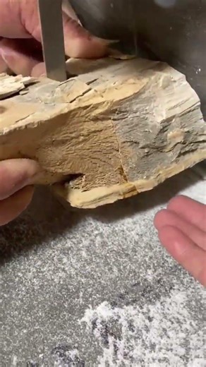 shaping a small piece of wood into a round object using an automated industrial wood lathe machine