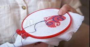 Woman learning to embroider. A female try to make a needle work in the room.