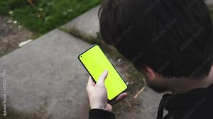 a man scrolling a smartphone, touching screen, searching information, checking messages, one person, close up view, focus on a screen, green screen