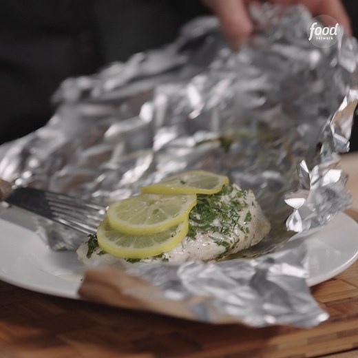 Alex Guarnaschelli bakes her seabass "En Papillote" in a pouch of folded foil with freshly sliced lemons and fresh herbs! #AlexVsAmerica takes on French cooking Sunday at 9|8c. Stream it the same day on discovery . #discoveryplus | Food Network