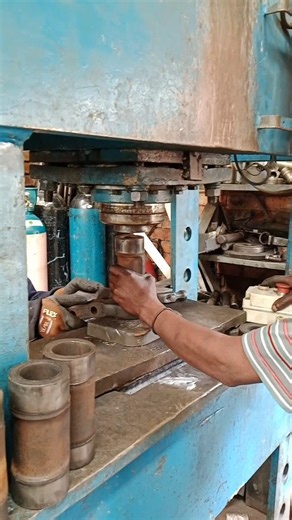 USING PRESSING MACHINE TO PUSH THROUGH PIN IN EXCAVATOR'S TRACK CHAIN LINK IN MECHANICAL WORKSHOP