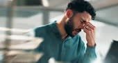 Businessman, headache and stress with laptop in blur from strain,...