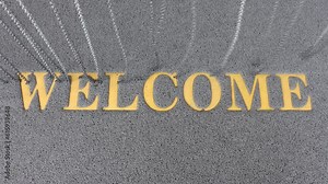 The inscription Welcome on a carpet under the hanged chains
