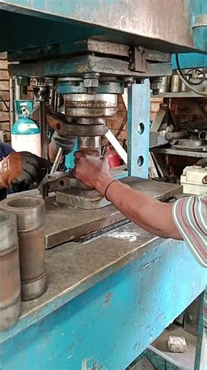 IN MECHANICAL WORKSHOP PRESSING THROUGH BUSHES AND PINS IN EXCAVATOR'S TRACK CHAIN WITH HYDRAULIC