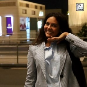 Actress Esha Gupta opted for a business casual airport look as she wore white pants, a blue shirt and a gingham blazer. #EshaGupta | Lehren