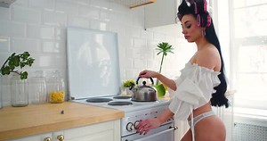 Young Sexy Woman in Beautiful Lingerie Cooks in the Morning in the Kitchen
