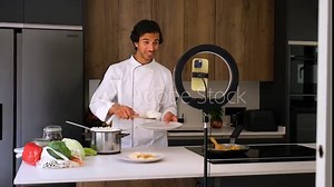 Professional chef demonstrating cooking techniques in a modern kitchen, presenting meal preparation step-by-step with a ring light and camera setup