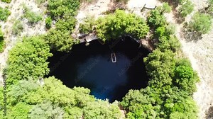 Aerial drone top view video of iconic open cave and lake of Melissani near port of Sami, Cefalonia island, Ionian, Greece
