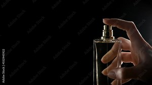 Splashes of perfume from a tube of perfume on a black background