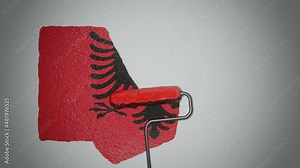 Roller paints the wall in colors of Albanian flag. Travel concept. Albania.