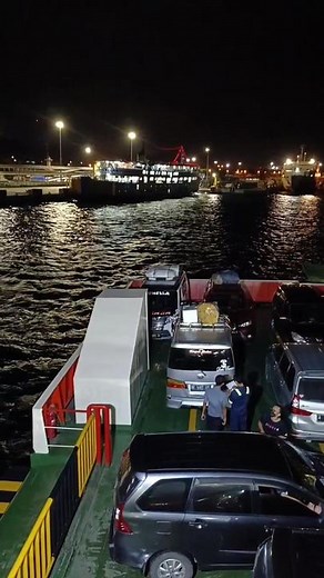 Nighttime Ferry Scene with Parked Vehicles