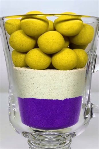 Yellow spheres atop white and purple layered sand