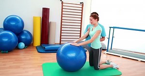 clip-5653010-trainer-helping-his-client-stretch-her-back