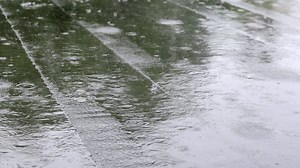 Raindrops knock on the roof, heavy rain, downpour. The flat roof of the building is covered with a waterproof material that protects from rain. Ruberoid, rolled roofing and waterproofing material.