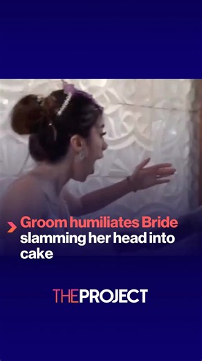 TheProjectTV (@theprojecttv) - Social media users are outraged at this groom's behaviour as he shoves his bride into their wedding cake, covering her hair in purple icing. Commenters are labelling it