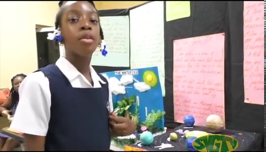 A student of the Rose Hall Government School shows off her creative model of a Solar System and Water Cycle at the National Science & Technology Fair taking place at the Methodist Church Hall in Kingstown | SVG TV