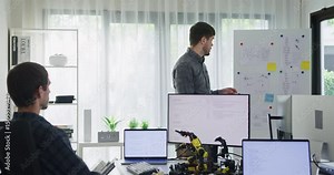 Team adult male engineer develop present AI robotics hand project at tech workspace. Artificial intelligence, collaboration support prototype development, robotic, debugging, machine learn, training.