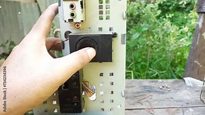 A technician checks old computer speakers. Spekaer attached to the computer casing