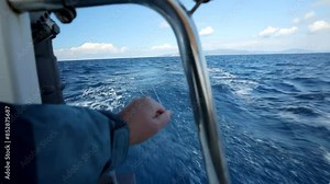 A man's hands straighten a fishing line going out to sea from the stern of a yacht at full speed. Fishing from boat stock Full HD video